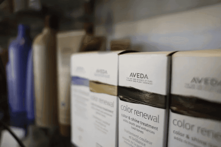 Shelf of Aveda hair products including color renewal treatment bottles.